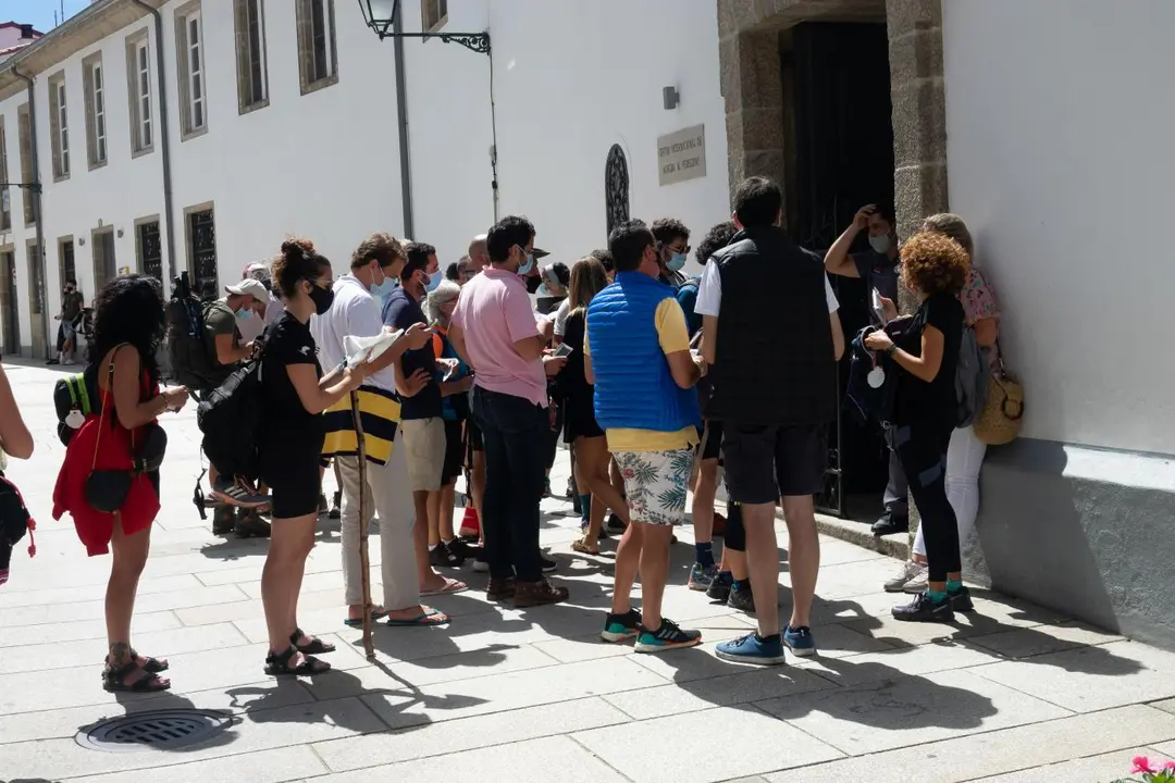 Peregrinos con mascarillas esperando su turno. - Europa Press