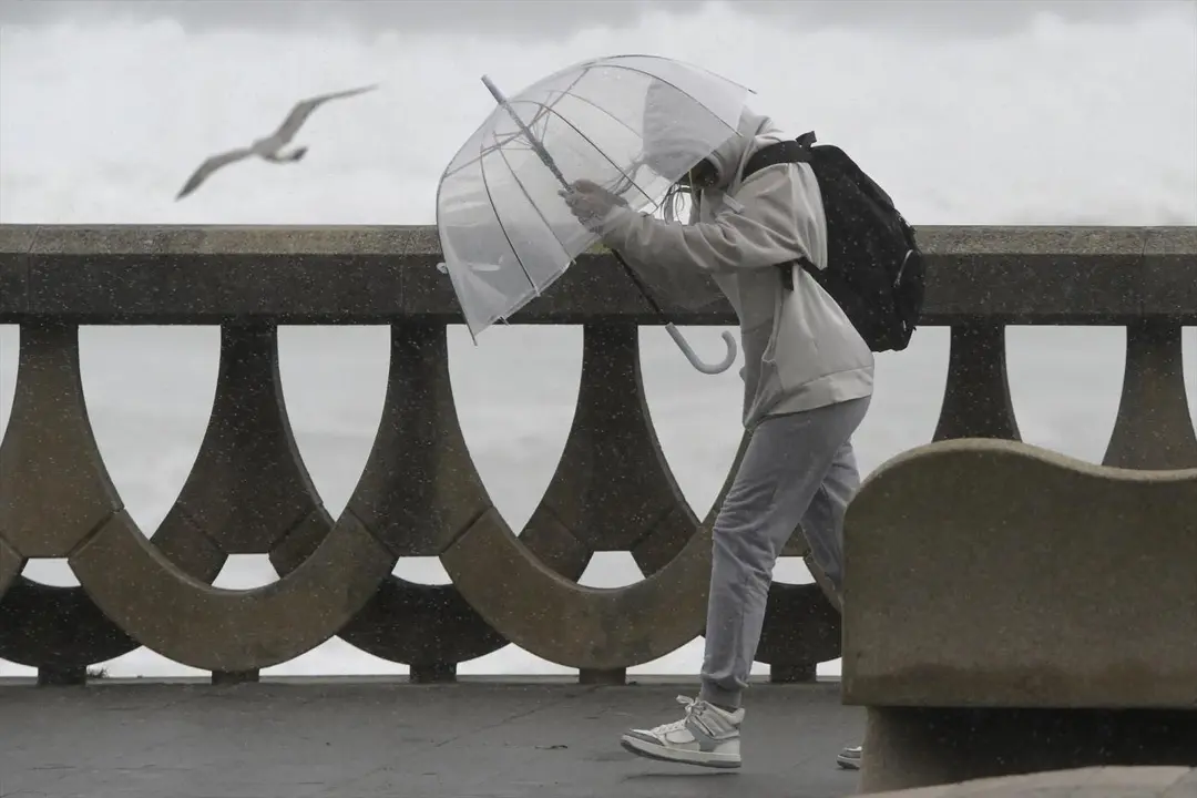 Una persona se protege de la lluvia y el viento con un paraguas. - ep