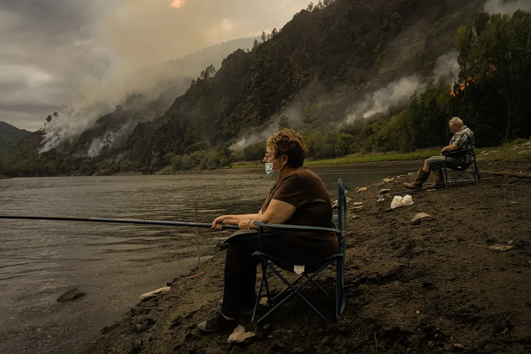 Una pareja pesca cerca el fuego. | Europa Press.