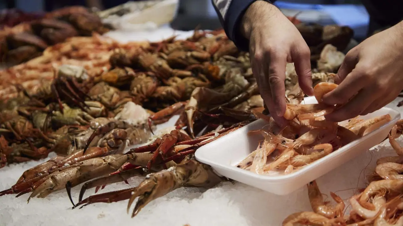 Un vendedor de marisco, prepara una bandeja de gambas en una foto de archivo. - JOAQU&Iacute;N CORCHERO / EUROPA PRESS
