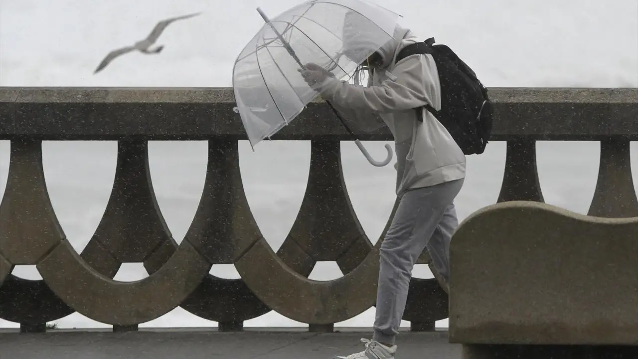 Una persona se protege de la lluvia y el viento con un paraguas. - ep