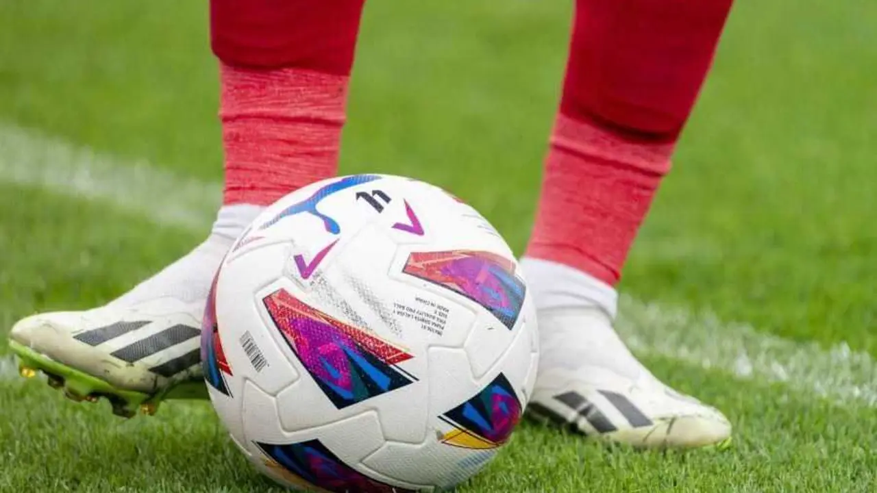 Los pies de un futbolista tocan el bal&oacute;n sobre el c&eacute;sped de un estadio de f&uacute;tbol. | LALIGA